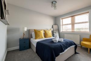 a bedroom with a bed with yellow pillows and a window at Rosemount - Kilrenny in Kilrenny