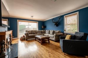 a living room with blue walls and couches at Rosemount - Kilrenny in Kilrenny