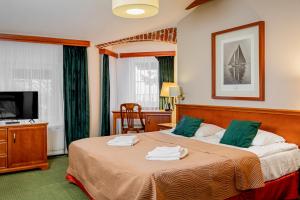 ein Hotelzimmer mit zwei Betten und einem Fernseher in der Unterkunft Meduza Hotel & Spa in Mielno