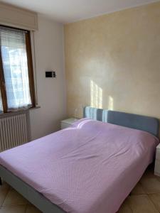 a bedroom with a bed with a pink blanket at Regina House Cattolica in Cattolica