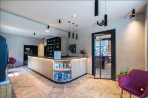 a lobby with a counter in a room with chairs at Hôtel Le Cor de Chasse in Saint-Hubert
