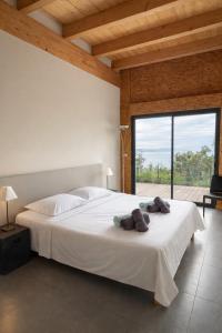 a bedroom with a large white bed and a large window at Casa Turrigiani in Sagone +110 photos