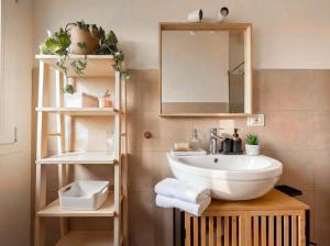 a bathroom with a sink and a mirror and shelves at PENTHOUSE ISEO LAKE VIEW - Free Wi-Fi and Private Parking Included in Sale Marasino