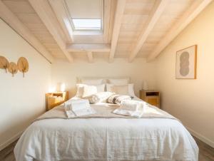 a bedroom with a bed with white sheets and pillows at PENTHOUSE ISEO LAKE VIEW - Free Wi-Fi and Private Parking Included in Sale Marasino