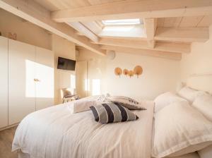 a bedroom with a white bed and a skylight at PENTHOUSE ISEO LAKE VIEW - Free Wi-Fi and Private Parking Included in Sale Marasino