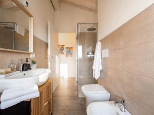 a bathroom with a white sink and a toilet at PENTHOUSE ISEO LAKE VIEW - Free Wi-Fi and Private Parking Included in Sale Marasino +14 photos