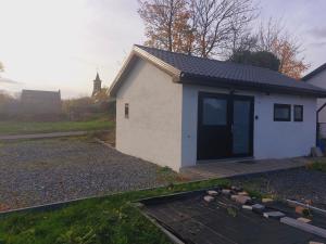 ein kleines weißes Gebäude mit einer Tür an der Seite in der Unterkunft Le sandron in Marchin