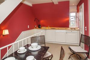 a kitchen with red walls and a table and chairs at Haus Peacock in Kampen +17 photos