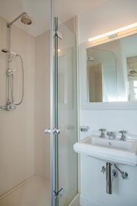 a bathroom with a shower and a sink and a mirror at Haus Peacock in Kampen
