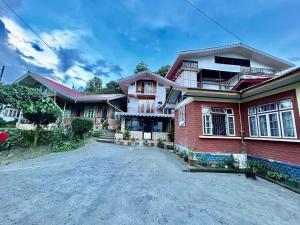 a large red brick house with a driveway at Soshing Homestay in Ravangla