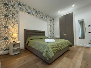 a bedroom with a bed with a green bedspread at Maison Trentasette in Potenza