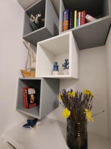 a white book shelf with a vase of flowers on a table at I Limoni in Sanremo