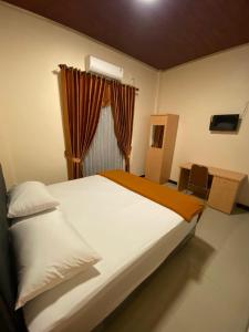 ein Schlafzimmer mit einem großen weißen Bett und einem Fenster in der Unterkunft Aco Borneo Hotel in Malinau