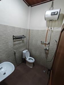 ein Badezimmer mit Toilette und Waschbecken in der Unterkunft Aco Borneo Hotel in Malinau
