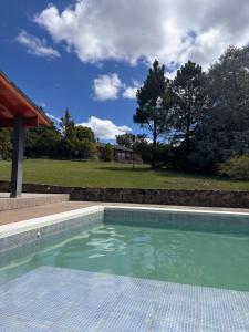 a swimming pool in a yard with a house at Cabaña julian in Villa Berna