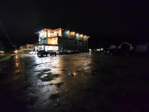 Ein beleuchtetes Gebäude auf einem Parkplatz bei Nacht in der Unterkunft Aco Borneo Hotel in Malinau + 28 Fotos
