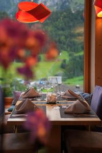 a wooden table with glasses and napkins and a window at Hotel Waldegg - Adults only in Engelberg