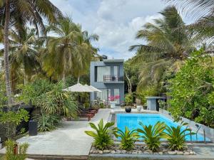 a villa with a swimming pool and palm trees at Endlessblue Resort Kalametiya in Kalametiya