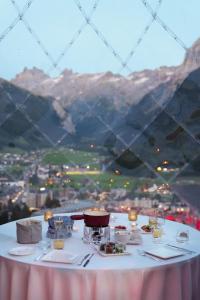 a table with plates of food and a view of mountains at Hotel Waldegg - Adults only in Engelberg