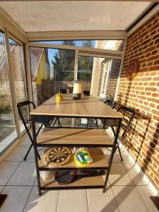 a table on a screened in porch with a window at Cocorico in Boué +16 photos
