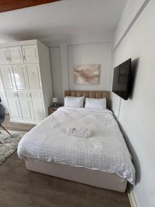 a bedroom with a white bed and a television at The Luxe Studio in Lusaka +14 photos