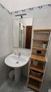 a bathroom with a sink and a mirror at Gaia Holidays Apartments in Cefalù +99 photos