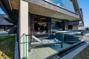 a glass extension of a house with a swimming pool at Crystal Peak Villas z prywatnym jacuzzi, Odkryj-Zakopane in Kościelisko