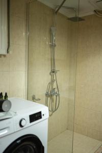 a shower in a bathroom with a washing machine at The Hidden Cellar by Heavens Hall in Alexandroupoli