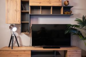 a flat screen tv sitting on top of a wooden entertainment center at The Hidden Cellar by Heavens Hall in Alexandroupoli