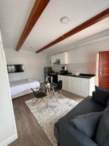 a living room with a couch and a table and a kitchen at The Luxe Studio in Lusaka