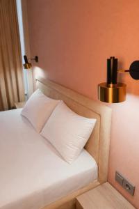 a bed with a white pillow next to a lamp at SAFIA Hotel in Pavlodar +24 photos