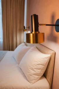 a lamp on top of a bed with a pillow at SAFIA Hotel in Pavlodar
