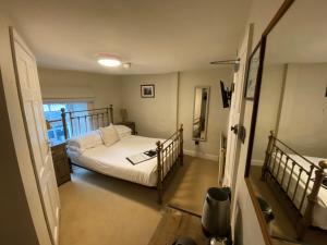 a small bedroom with a bed and a window at The Cavendish Arms in Cartmel