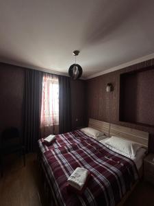 a bedroom with a large bed with a striped blanket at Guest house chavchavadze N23 in Kazbegi