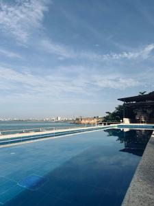 a swimming pool with a view of the ocean at Hotel Sokhamon in Dakar
