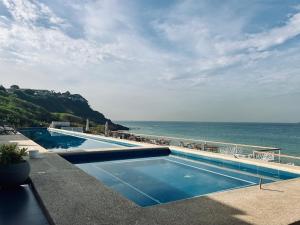 a swimming pool with a view of the ocean at Hotel Sokhamon in Dakar +26 photos