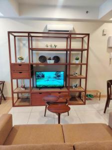 a living room with a entertainment center with a tv at Timurbay Seafront By Ocean waves in Kuantan