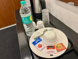 a table with a plate and a bottle of water at Hotel unity Park in Pondicherry +55 photos