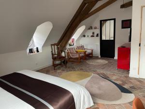 a bedroom with a bed and a table and chairs at Le Petit Monde de Molly in Toucy