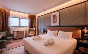a hotel room with a bed with towels on it at Savhotel Mantegna Padova in Padova