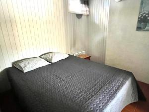 a bedroom with a black bed with two pillows at Vuohensaari, Rantatalo 5 in Salo