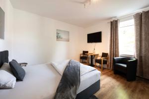 a bedroom with a bed and a chair and a desk at N4 - Apartments Fulda Free Parking & Zentral in Fulda