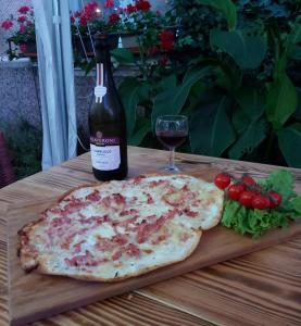 a bottle of wine and a pizza on a table with a glass at chambres d'hotes Lagarde in Lagarde +17 photos