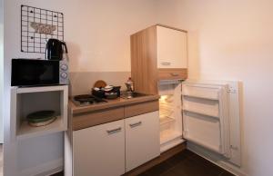 a small kitchen with a refrigerator and a sink at N4 - Apartments Fulda Free Parking & Zentral in Fulda