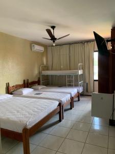 a bedroom with two beds and a ceiling fan at Pousada Malu in Fortaleza