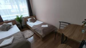 a small room with two beds and a table at Leśna Przystań in Iława +9 photos