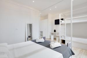 a white bedroom with a large bed with two towels at Evo Boutique Hotel & SPA in Bellaria-Igea Marina