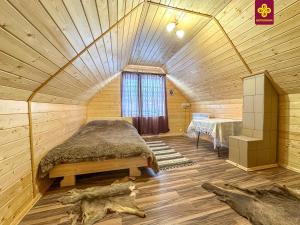 a bedroom with a bed in a wooden cabin at Трофейна хатина in Krivopolʼye