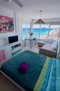 a room with a bed and a living room with the ocean at Un Rincon en el Mar in Bellreguart