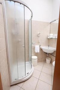 a bathroom with a shower and a toilet and a sink at Hotel Villa Tina Easy Stay B&B in Cesenatico